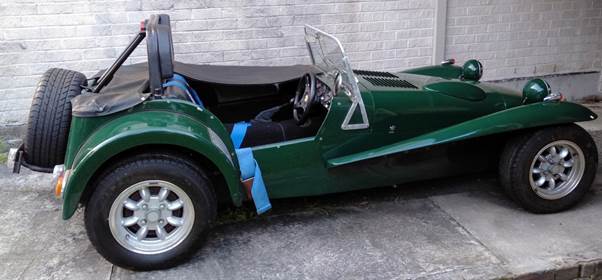 A green car parked next to a brick wall

Description automatically generated with medium confidence